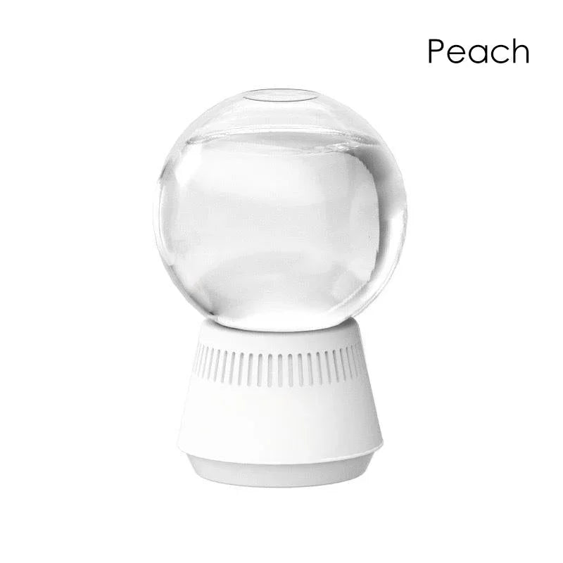 Clarioy peach essential oil diffuser with clear glass globe and white base, minimalist homeware.