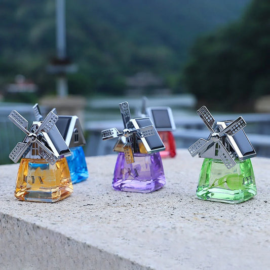 Colorful windmill-shaped car air fresheners with silver tops, displayed outdoors on a stone ledge