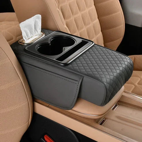 Black quilted car armrest organizer with cup holders and tissue slot on tan leather seats