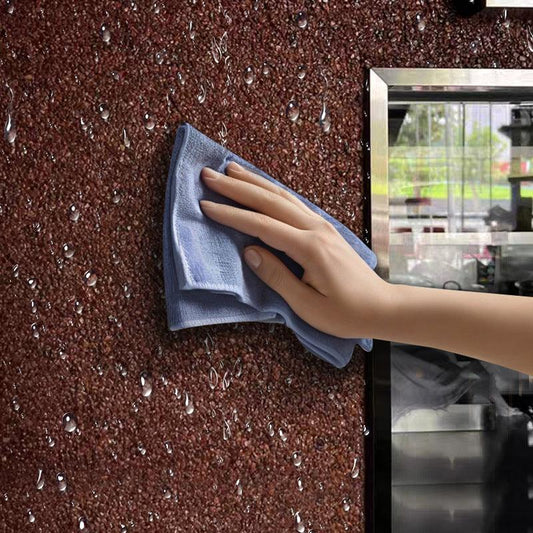 Hand cleaning wet brown wall with blue microfiber cloth, home cleaning tool from clarioy