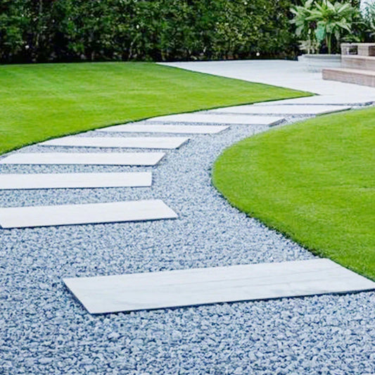 Modern garden with white stone pavers on a gravel path and green lawn, outdoor decor at clarioy