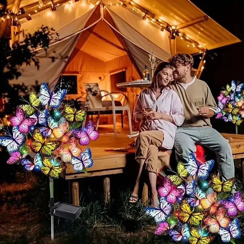 Couple relaxing at night by a lit tent with colorful butterfly solar garden lights, clarioy homeware
