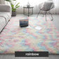 Modern living room with a pastel rainbow fluffy rug, laptop, and accent furniture by clarioy