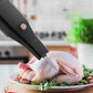 Electric meat injector tool puncturing raw chicken on plate with herbs, kitchen background, clarioy