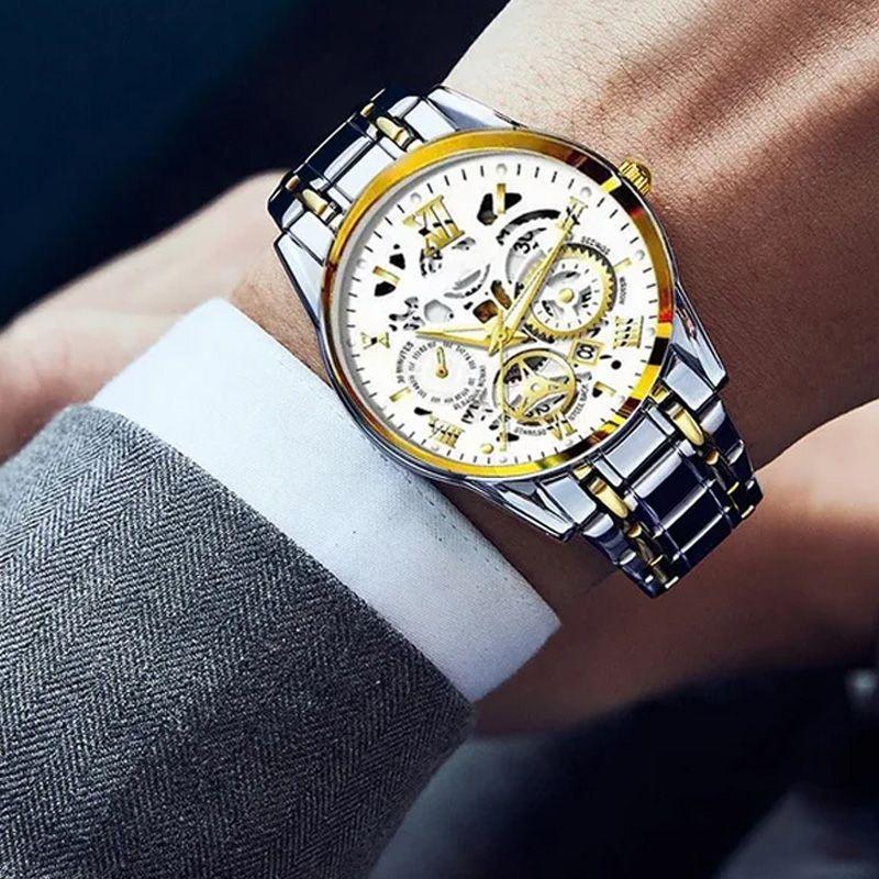 Luxury silver and gold skeleton watch with metal band, worn with a grey suit, clarioy premium accessory