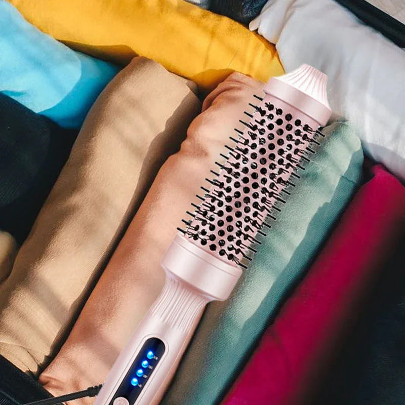 Pink electric hair styling brush with LED display on neatly folded clothes, clarioy homeware
