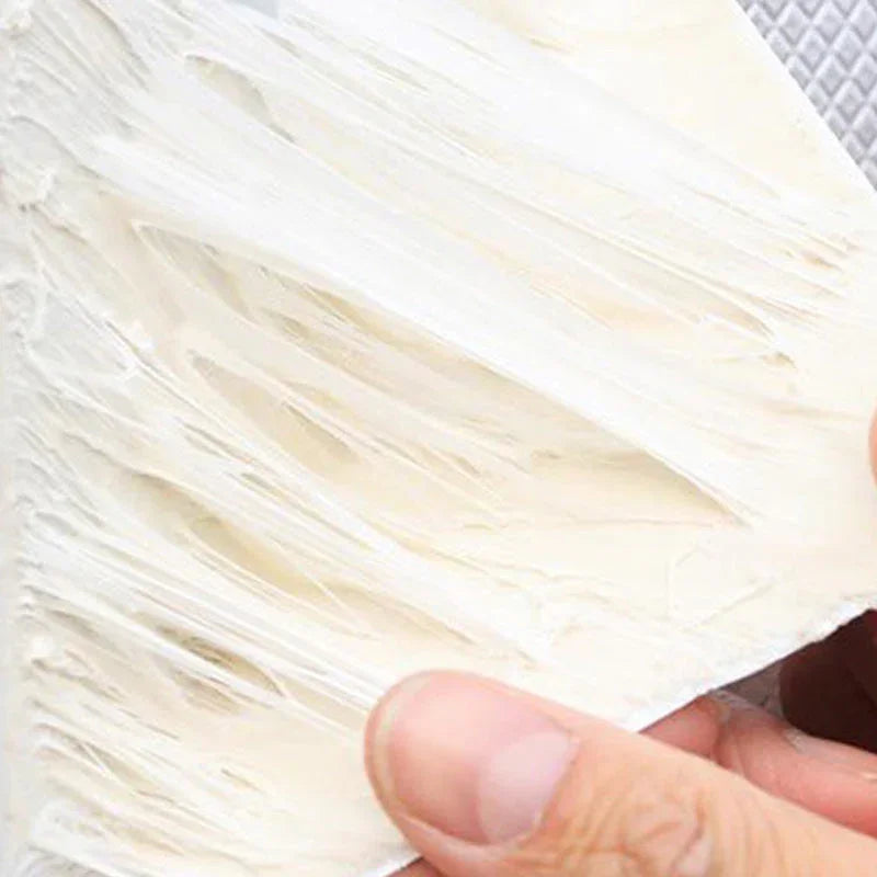 Close-up of a hand holding shredded white fiber material, homeware product at clarioy