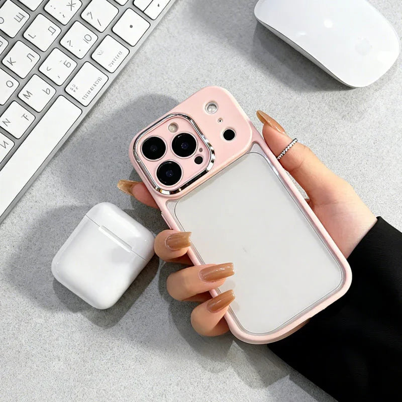 Hand holding iPhone with pink case near wireless earbuds, keyboard, and mouse on desk