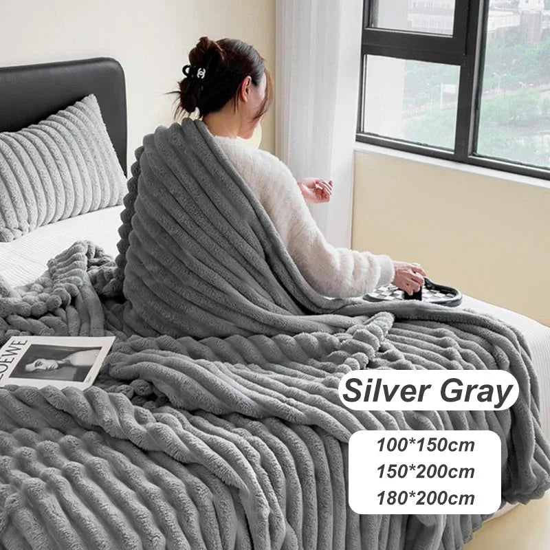 Woman sitting on bed with textured silver gray blanket, cozy homeware by clarioy.