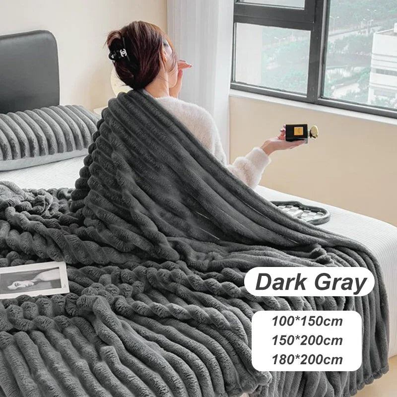 Woman on bed with plush dark gray flannel blanket, clarioy homeware, available in three sizes