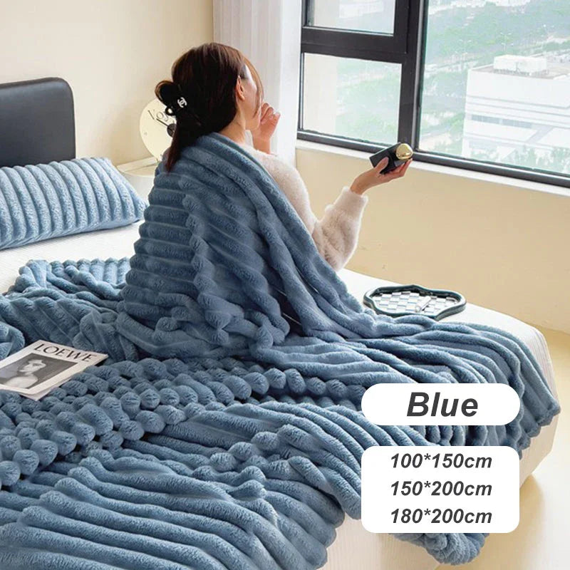 Woman sitting on bed with plush blue textured blanket and pillow by window, clarioy homeware