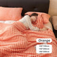 Woman sleeping on bed with soft orange ribbed blanket and pillow, clarioy bedding homeware