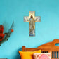 Decorative Jesus cross wall art in a blue bedroom with wooden bed and colorful pillows