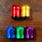 Set of five colorful metallic auto valve caps on wooden surface, clarioy car accessories