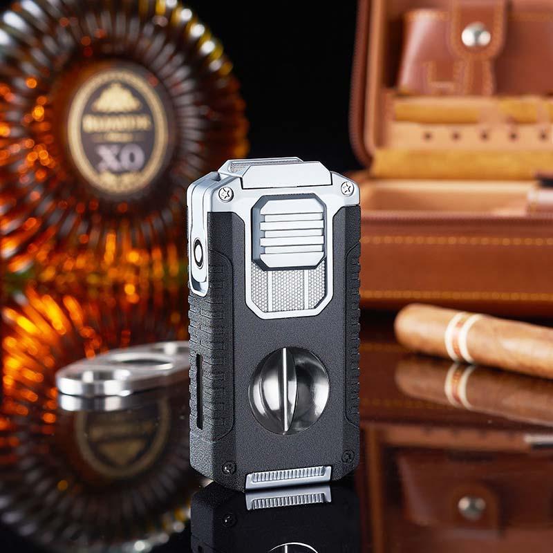 Clarioy premium cigar cutter and lighter on reflective table with whiskey and cigar accessories