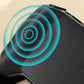 Close-up of a black wireless device speaker emitting sound waves, premium electronics by clarioy