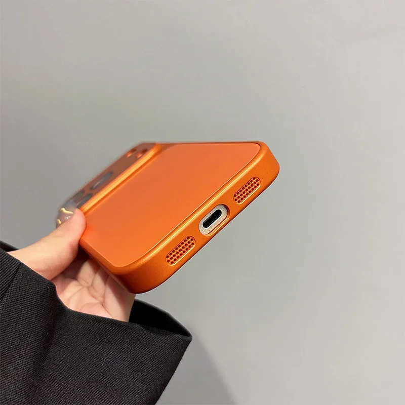 Hand holding orange iPhone case with precise port cutouts, clarioy electronics accessory