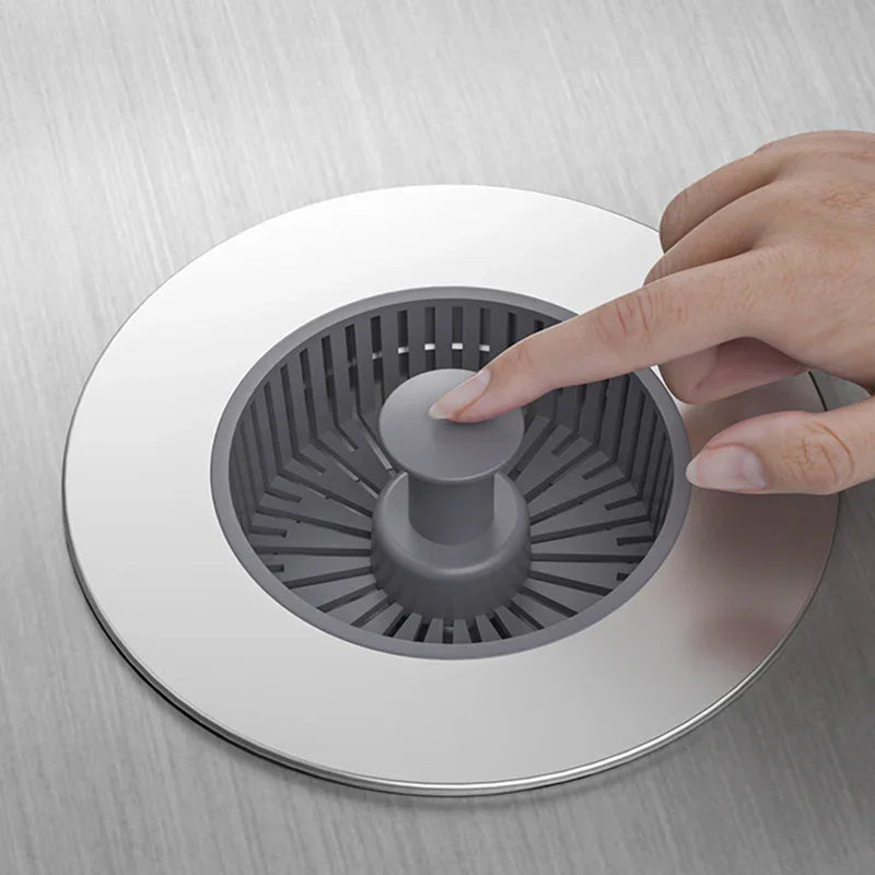 Hand pressing modern grey sink strainer in stainless steel kitchen, clarioy homeware tool